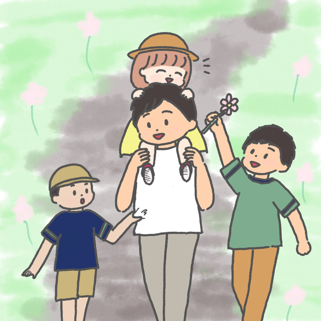 Tシャツを着たお父さんと3人の子供たち（肩車された小さい女の子とお父さんの隣を歩く２人の男の子）