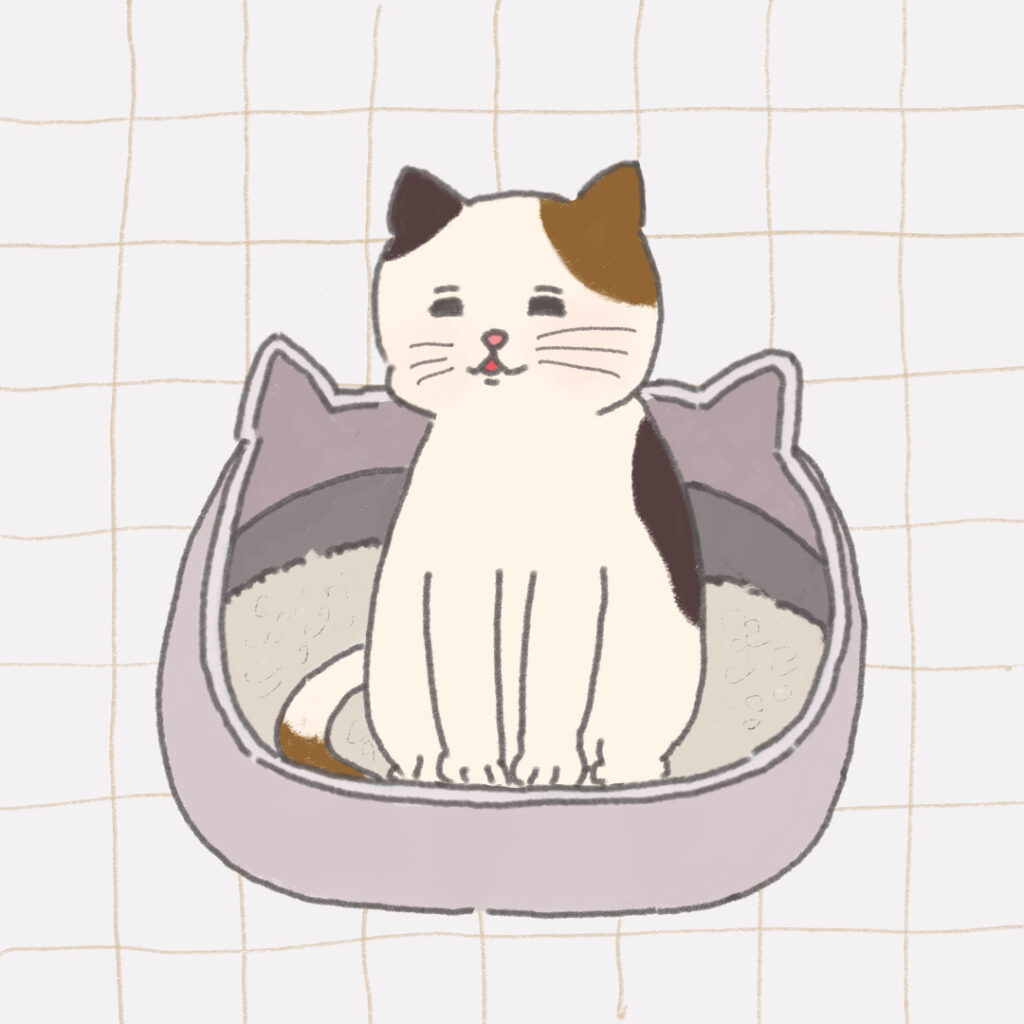 ねこ型の猫用トイレに座っているまだらのぶちねこ